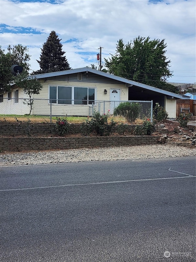 view of front of house with an attached carport and fence private yard