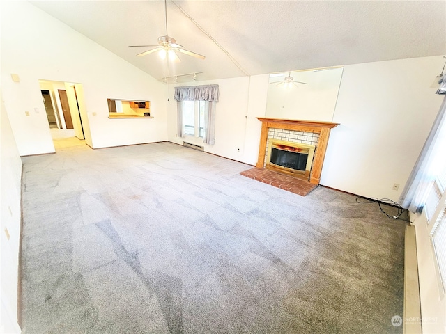 unfurnished living room with high vaulted ceiling, a tiled fireplace, ceiling fan, and light colored carpet