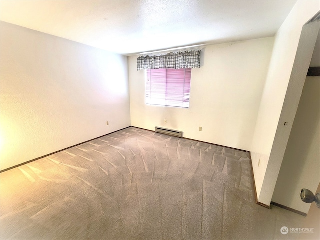 carpeted empty room featuring a baseboard radiator