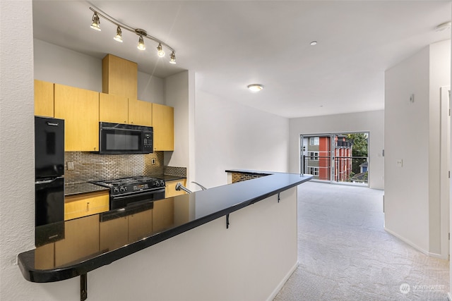 kitchen with black appliances, kitchen peninsula, a breakfast bar area, and light colored carpet