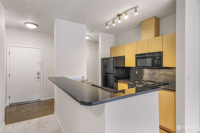 kitchen with decorative backsplash, black appliances, light brown cabinetry, and sink