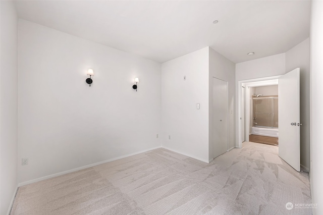 unfurnished bedroom featuring light colored carpet and a closet