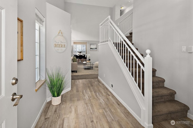 foyer entrance featuring a high ceiling and light hardwood / wood-style floors