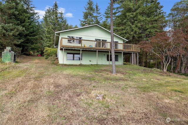 back of house with a wooden deck and a lawn