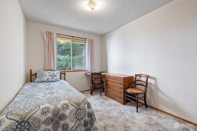 bedroom with light carpet and a textured ceiling