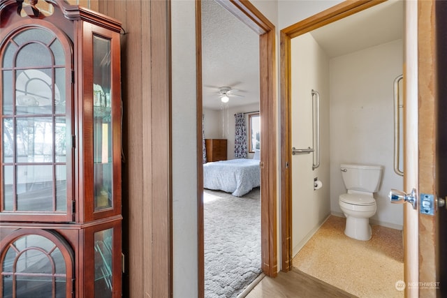 bathroom with a wealth of natural light, ceiling fan, a textured ceiling, and toilet