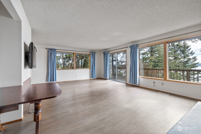 unfurnished living room with a textured ceiling and hardwood / wood-style floors