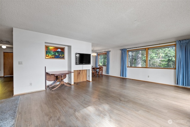 unfurnished living room with a textured ceiling and hardwood / wood-style floors