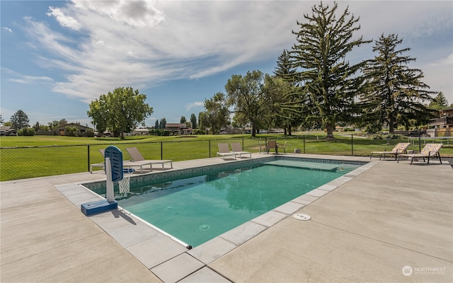 view of pool featuring a lawn and a patio