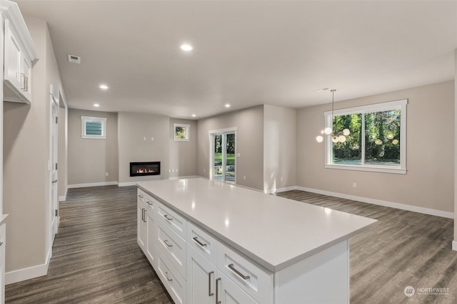 kitchen featuring white cabinets, pendant lighting, dark hardwood / wood-style flooring, and a kitchen island