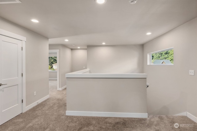 hall with light colored carpet and plenty of natural light