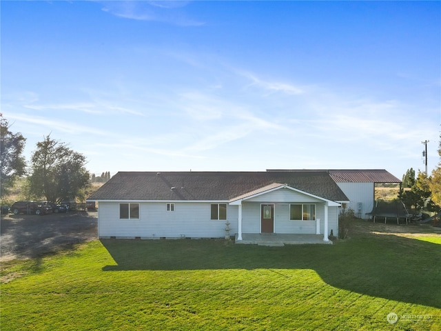 rear view of property featuring a lawn