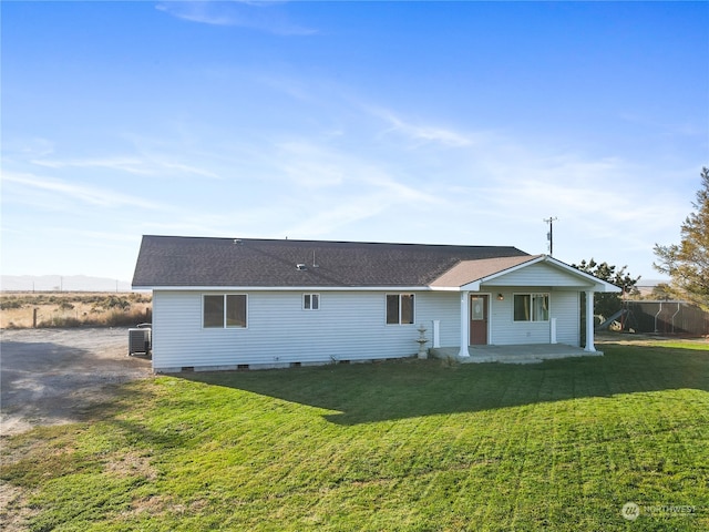 rear view of property featuring central AC and a yard