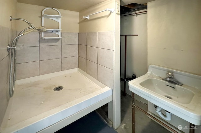 bathroom featuring tile walls, walk in shower, and sink