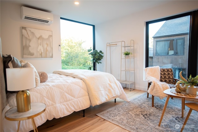 bedroom featuring hardwood / wood-style floors and a wall mounted air conditioner