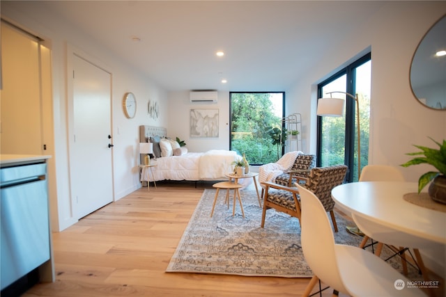 bedroom featuring an AC wall unit and light hardwood / wood-style flooring