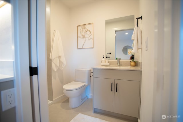 bathroom with tile patterned flooring, vanity, and toilet