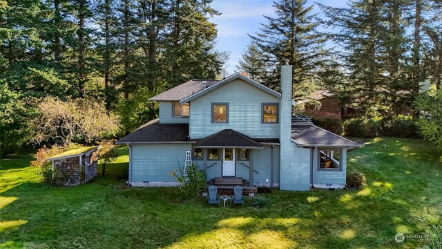 rear view of property featuring a lawn