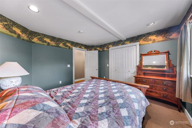 bedroom featuring carpet, a closet, and beamed ceiling