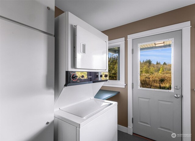 laundry room with stacked washer and dryer and a healthy amount of sunlight