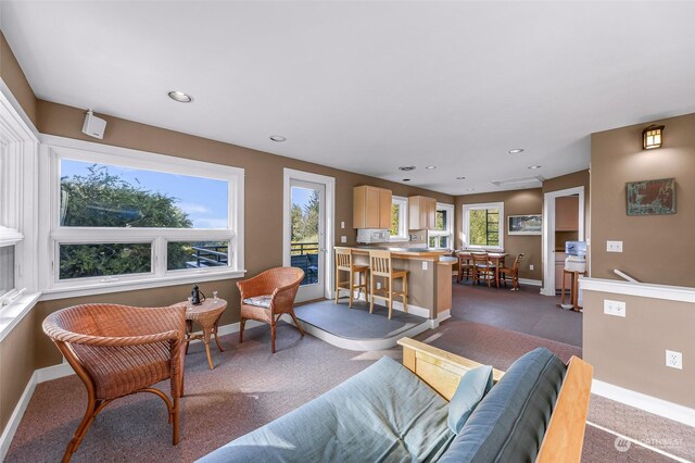 living room with a wealth of natural light and dark colored carpet