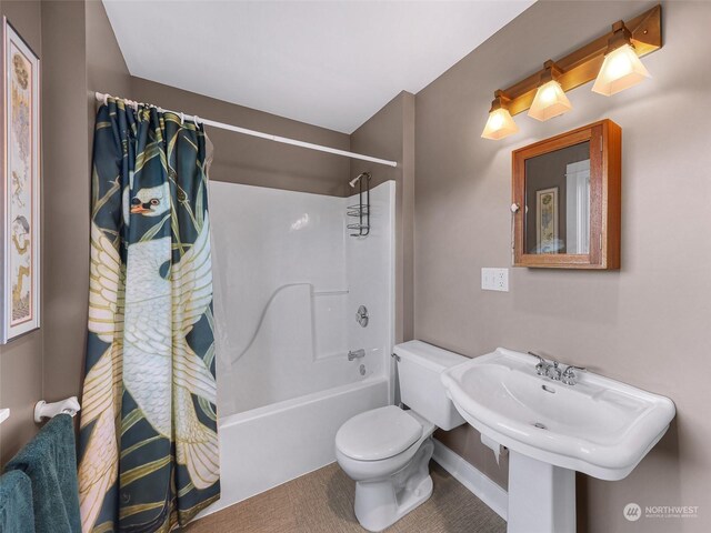 bathroom featuring shower / tub combo with curtain and toilet