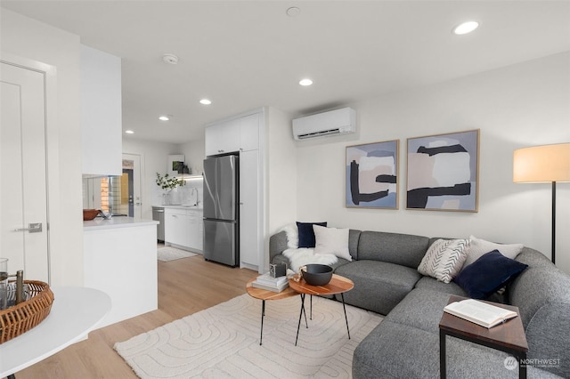 living room featuring sink, light hardwood / wood-style floors, and an AC wall unit