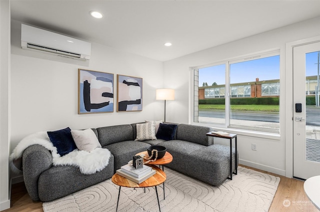 living room with an AC wall unit and light wood-type flooring