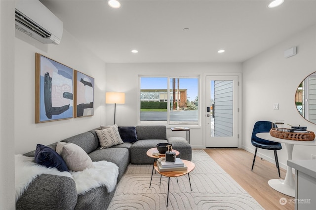 living room featuring an AC wall unit and light hardwood / wood-style flooring