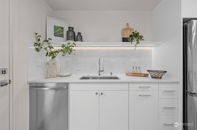 bar with sink, white cabinets, stainless steel appliances, and decorative backsplash