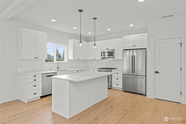 kitchen with light wood-type flooring, hanging light fixtures, a center island, and stainless steel appliances