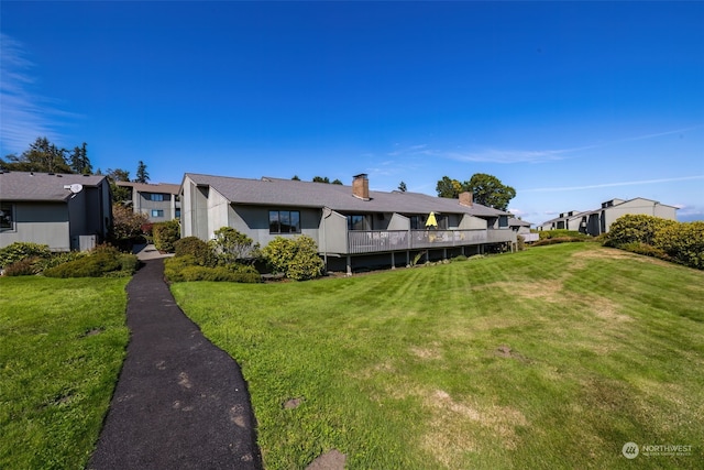 exterior space featuring a wooden deck and a front lawn