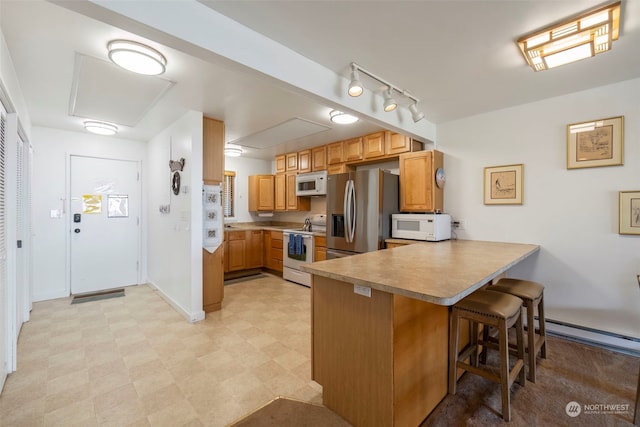 kitchen featuring kitchen peninsula, white appliances, and a breakfast bar