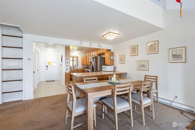 carpeted dining space with track lighting and sink