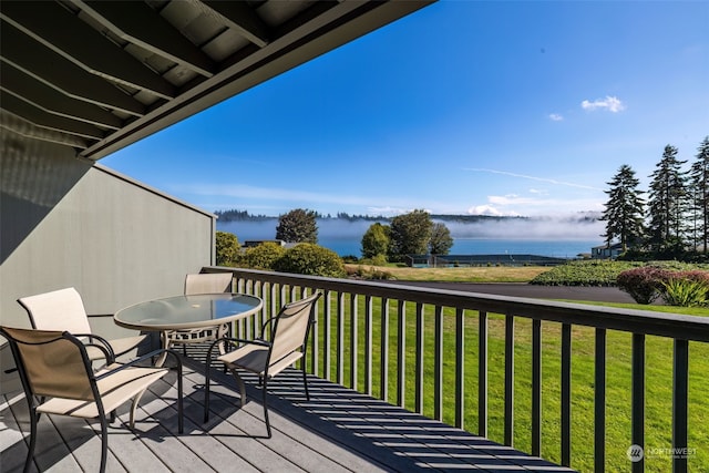 wooden deck featuring a yard and a water view