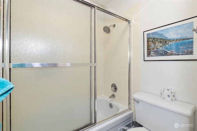 bathroom featuring enclosed tub / shower combo and toilet