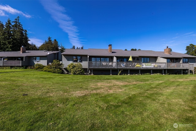 back of property with a lawn and a deck