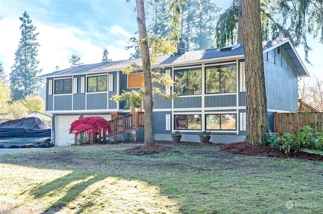 rear view of property with a lawn and a garage