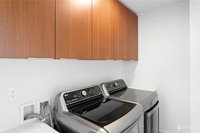 washroom with cabinets and washing machine and clothes dryer