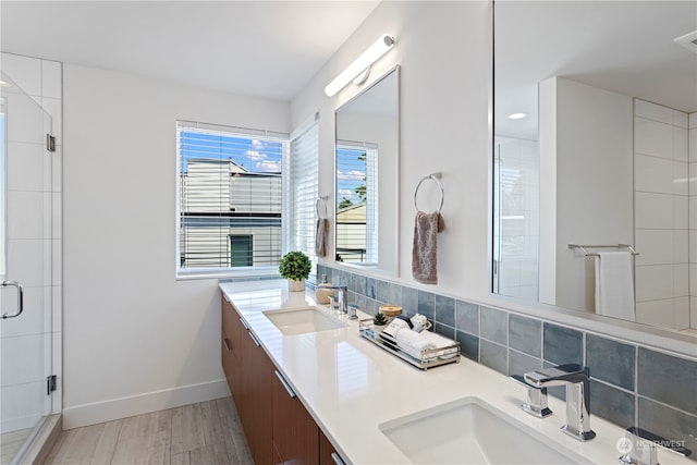 bathroom featuring backsplash, hardwood / wood-style floors, walk in shower, and vanity