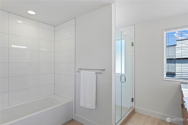 bathroom with shower with separate bathtub, hardwood / wood-style floors, and vanity