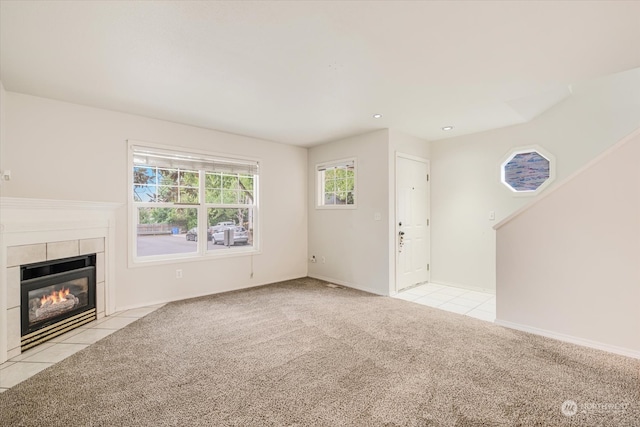 unfurnished living room featuring light colored carpet and a tile fireplace