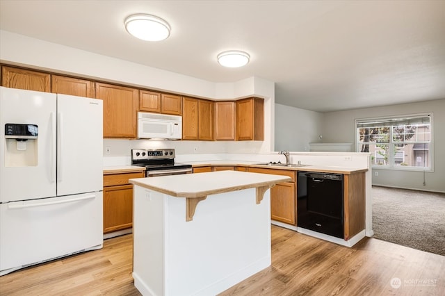 kitchen featuring light hardwood / wood-style floors, white appliances, and a kitchen island