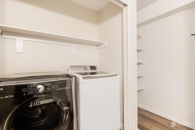 laundry area with independent washer and dryer and hardwood / wood-style flooring