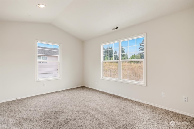 empty room featuring carpet flooring and vaulted ceiling