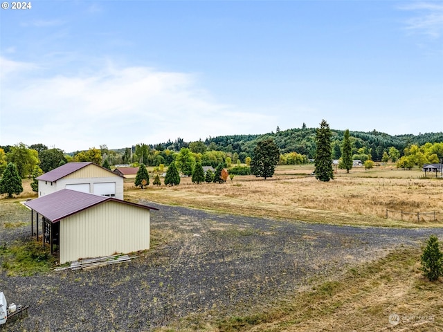 view of yard featuring an outdoor structure and a rural view