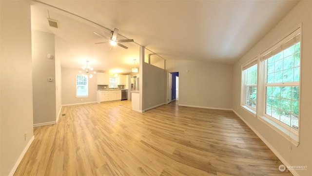 unfurnished living room with ceiling fan with notable chandelier, lofted ceiling, and light hardwood / wood-style flooring