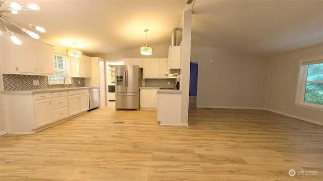 kitchen featuring pendant lighting, white cabinets, vaulted ceiling, stainless steel appliances, and light hardwood / wood-style floors