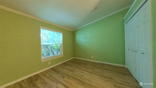 unfurnished bedroom with light wood-type flooring, a closet, and crown molding