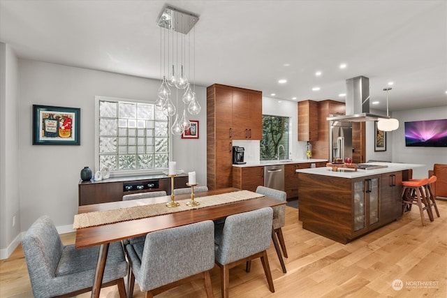 dining space with light wood-type flooring and sink